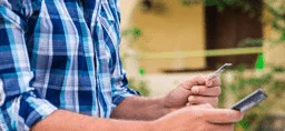 Young man using a smartphone to buy medicines from a verified canadian pharmacy Young man using a smartphone to buy medicines from a verified canadian pharmacy
